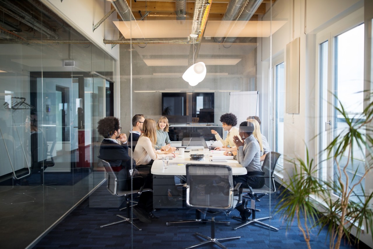 Business people having board meeting in modern office. Diverse group of people having meeting in conference room.