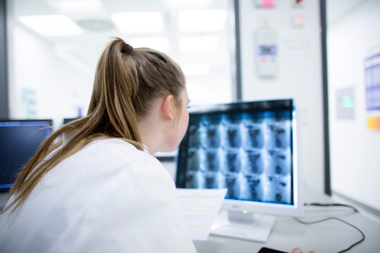 Young doctor in hospital looking at computer screen