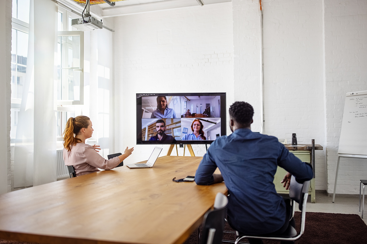 Businesspeople having a video conference in office. Business men  and women having a web conference in office board room.