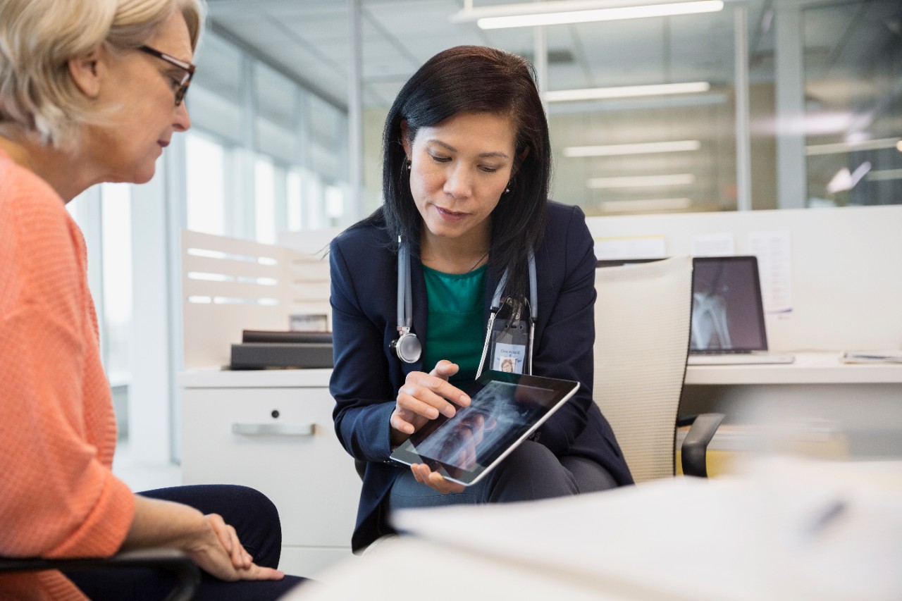 Doctor showing digital tablet xray to patient