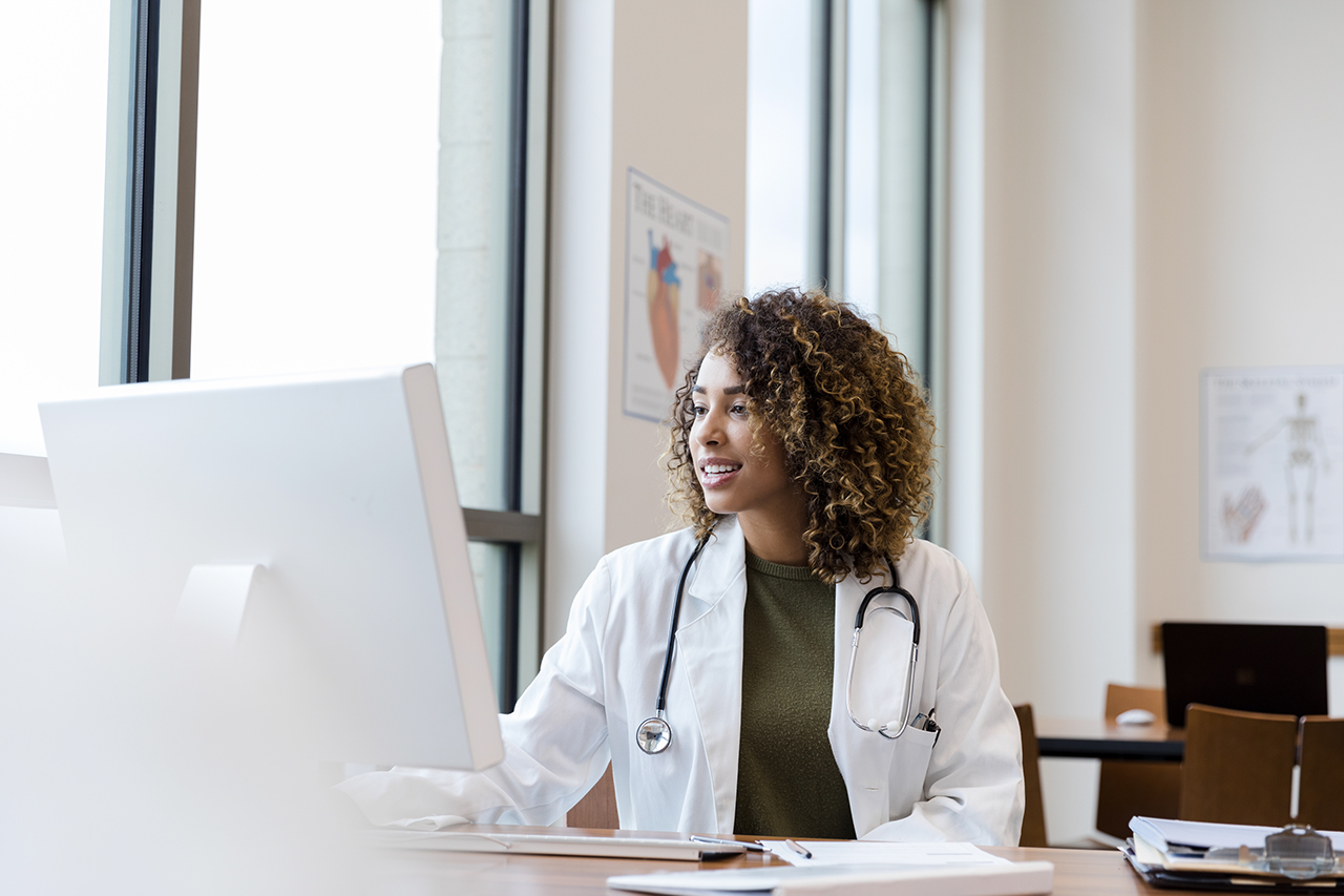 Doctor reviews her patient's records on her computer in her office