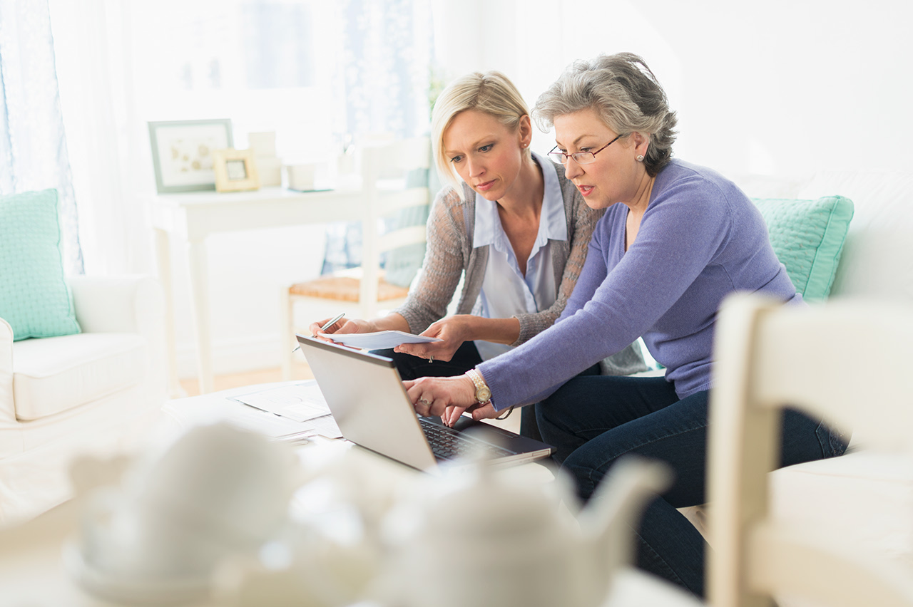 Two women paying bills