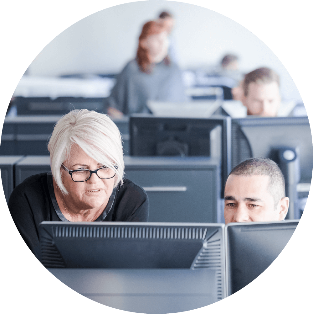 Man and woman talking while looking at computer screen